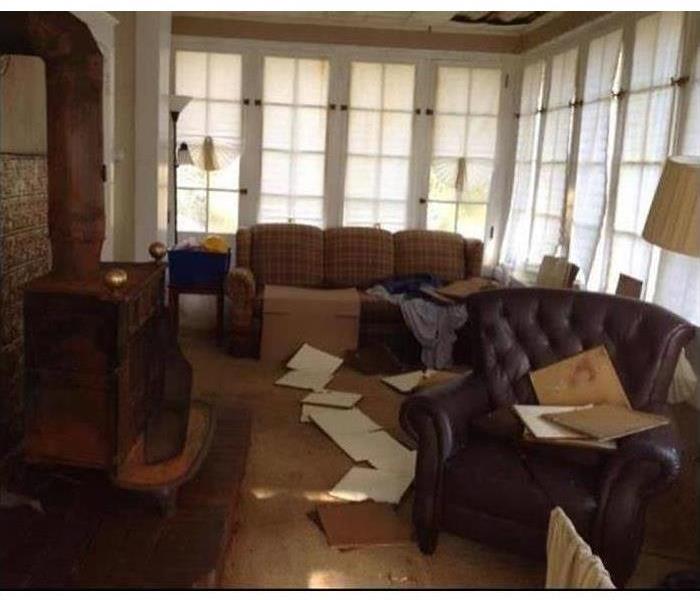 Room with couches and chairs damaged by water.