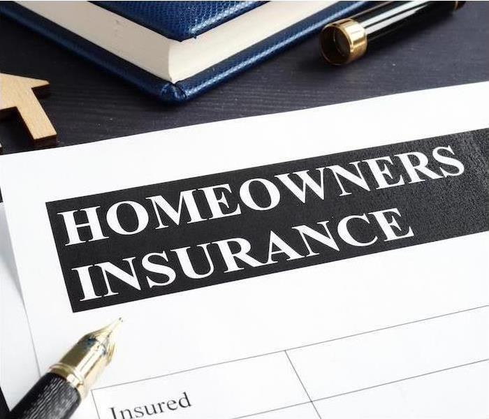 Paperwork with Homeowners Insurance on top of the form.